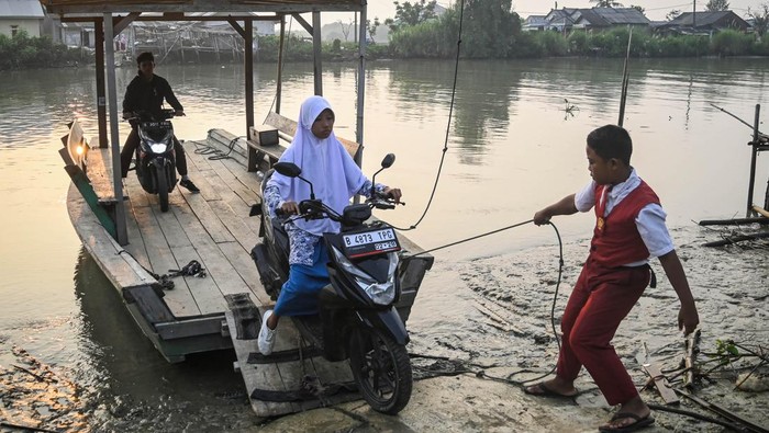 Siswa di Muara Gembong Gunakan Eretan untuk Berangkat Sekolah Sejumlah siswa menaiki eretan menyeberangi Sungai Citarum di kawasan Desa Pantai Bahagia, Muara Gembong, Kabupaten Bekasi, Jawa Barat, Selasa (8/5/2024). Para siswa menggunakan eretan sebagai moda penyeberangan menuju sekolah dengan tarif Rp2 ribu guna mempersingkat jarak tempuh karena minimnya akses jembatan penyebarangan di wilayah tersebut. ANTARA FOTO/Sulthony Hasanuddin/foc.