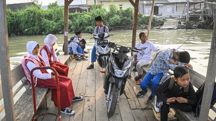 Siswa di Muara Gembong Gunakan Eretan untuk Berangkat Sekolah Sejumlah siswa menaiki eretan menyeberangi Sungai Citarum di kawasan Desa Pantai Bahagia, Muara Gembong, Kabupaten Bekasi, Jawa Barat, Selasa (8/5/2024). Para siswa menggunakan eretan sebagai moda penyeberangan menuju sekolah dengan tarif Rp2 ribu guna mempersingkat jarak tempuh karena minimnya akses jembatan penyebarangan di wilayah tersebut. ANTARA FOTO/Sulthony Hasanuddin/foc.