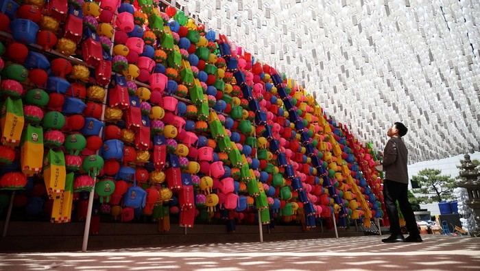 Warna-warni Lentera Teratai Jelang Perayaan Waisak di Korsel A woman prays underneath lotus lanterns attached to prayer petitions at Jogye temple in Seoul, South Korea, May 8, 2024. REUTERS/Kim Hong-Ji