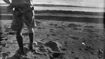 Seorang tentara Jepang mengarungi laut lepas Cape Endaiadere, New Guinea, dengan sebuah granat menempel di kepalanya beberapa saat sebelum meledak, menentang seorang tentara Australia yang memintanya untuk menyerah, 18 Desember 1942 Foto: HistoryDefined