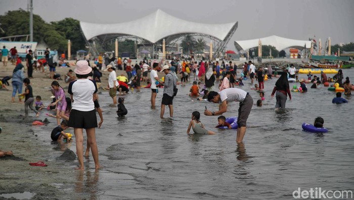 Libur Panjang, Pantai Ancol Diserbu Pengunjung Sejumlah pengunjung menikmati pantai di Taman Impian Jaya Ancol, Jakarta Utara, Kamis (9/5/2024).