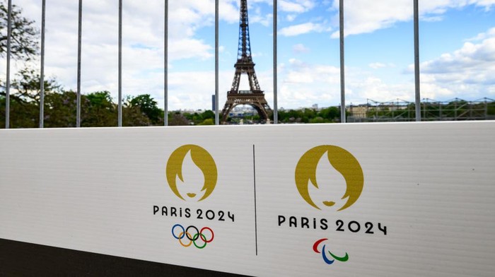 06 May 2024, France, Paris: The Olympic rings and the Paralympic Games logo can be seen on a sign on a construction fence in front of the Eiffel Tower. The Olympic Games and Paralympics take place in France this summer. Photo: Robert Michael/dpa (Photo by Robert Michael/picture alliance via Getty Images)