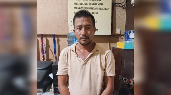 Pelaku penganiaya tukang becak lansia saat diamankan di Polsek Labuhan Ruku. (Istimewa)