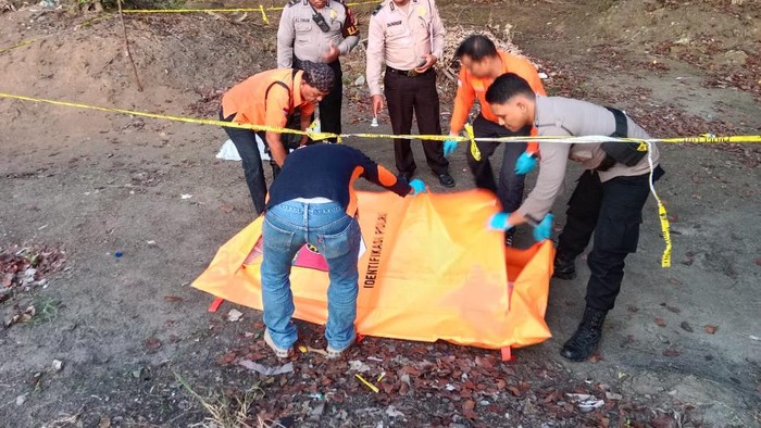 Petugas kepolisian saat mengevakuasi jasad nenek tanpa busana.