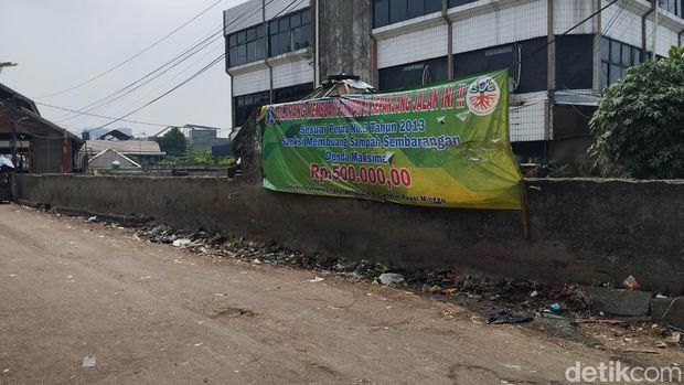 Petugas Sudin DLH Jakarta Selatan mengingatkan warga agar membuang sampah di TPS Lokbin Sentra Buah dan Sayur Pasar Minggu sesuai jadwal (Fawdi/detikcom)