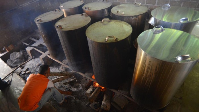 Penjual menambahkan kayu bakar untuk memasak air di depot air minum di Jalan Sungai Sirah Surantih, Pesisir Selatan, Sumatera Barat, Rabu (8/5/2024). Depot tersebut menyediakan air minum yang sudah dimasak, didinginkan dan disaring dua kali yang menjadi solusi sementara bagi warga yang berada di wilayah Kejadian Luar Biasa (KLB) Diare karena diduga akibat air minum tercemar.  ANTARA FOTO/Iggoy el Fitra/nym.