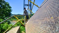 Jembatan yang putus akibat banjir bandang dua bulan lalu itu masih digunakan warga yang mayoritas petani karena menjadi satu-satunya akses ke ladang dan kebun mereka.  