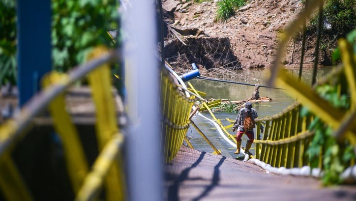 Tolong! Jembatan Rusak di Pesisir Selatan Diterjang Banjir Warga menyeberangi jembatan yang rusak di Nagari Duku Utara, Kecamatan Koto XI Tarusan, Pesisir Selatan, Sumatera Barat, Kamis (9/5/2024). Jembatan yang putus akibat banjir bandang dua bulan lalu itu masih digunakan warga yang mayoritas petani karena menjadi satu-satunya akses ke ladang dan kebun mereka. ANTARA FOTO/Iggoy el Fitra/YU
