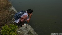 Seorang siswa pun terlihat mencuci wajah di aliran sungai ini.