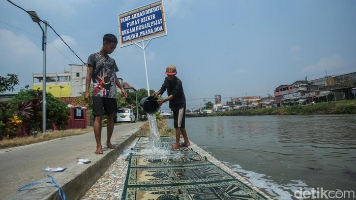 Aktivitas Warga Karawang Mencuci Baju hingga Sajadah Masjid di Sungai Warga mencuci sajadah masjid di aliran Sungai Citarum, Rengasdengklok, Karawang, Rabu (7/5/2024).