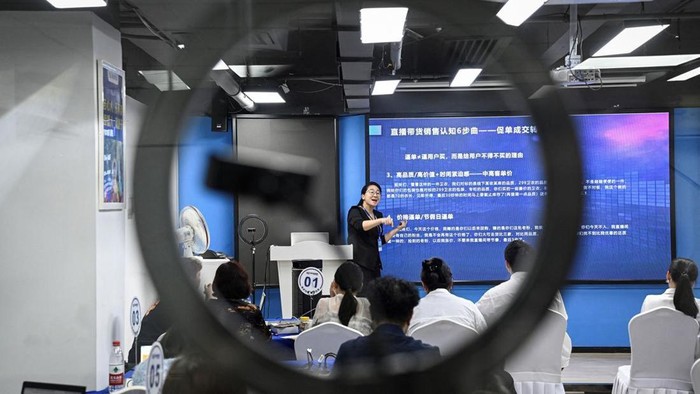 Seorang instruktur, Wang Yaxuan, tengah mengajarkan sejumlah muridnya cara menjual merchandise melalui platform TikTok di sekolah e-commerce Mede Education di Guangzhou, Guangdong, China.