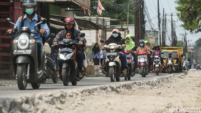 Perbaikan Jalan Rusak di CBL Bekasi Dikebut Pengendara melintas di jalan Raya Kali CBL, Bekasi, Rabu (7/5/2024).