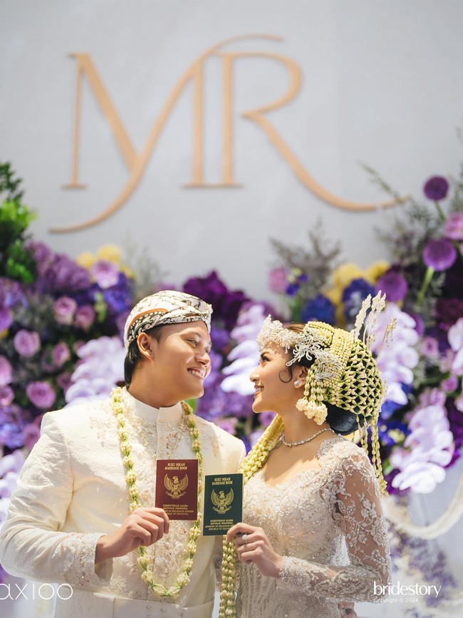 Nuansa ungu tampak kontras dengan latar belakang putih terang yang menonjolkan keindahan dekorasi bunga yang tertata indah nan apik. Foto: Dok. The Bridestory, Axioo