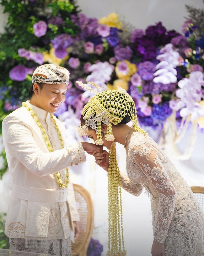 “Kami sepakat untuk mengedepankan tradisi pernikahan dari adat Sunda, yang merupakan latar belakang keluarga Iky, pada hari ini untuk menyeimbangkan prosesi dan ritual adat Bali yang sudah kami jalankan pada tanggal 5 Mei silam. Sehingga seluruh rangkaian acara memiliki sentuhan ragam budaya serta adat Bali dan Sunda yang mewakili kedua belah pihak keluarga kami,” ujar Mahalini kepada Bridestory. Foto: Dok. The Bridestory, Axioo