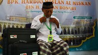 Calon haji Hardjo Mislan alias Miskan mencoba mengalungkan kartu identitas Haji di rumahnya Desa Bedingin, Kecamatan Sambit, Kabupaten Ponorogo, Jawa Timur, Sabtu (11/5/2024).