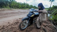 Tidak jarang para pengendara harus menuntut sepeda motornya saat melintasi Jalan Jambi-Suak Kandis yang rusak tersebut.