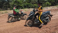 Pengendara melintas pelan di Jalan Jambi-Suak Kandis yang rusak di Pulau Tigo, Muaro Jambi, Jambi, Sabtu (11/5/2024).