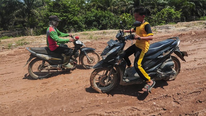 Pengendara mendorong sepeda motornya saat melintasi Jalan Jambi-Suak Kandis yang rusak di Pulau Tigo, Muaro Jambi, Jambi, Sabtu (11/5/2024). Jalan provinsi yang menghubungkan sejumlah desa di Muaro Jambi dan Tanjung Jabung Timur itu berlubang dan licin di sejumlah titik sehingga membahayakan pengendara yang melintas. ANTARA FOTO/Wahdi Septiawan/nz.