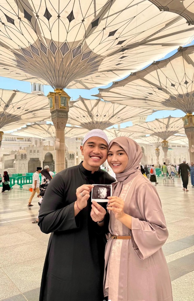 Erina Gudono dan Kaesang Pangarep mengumumkan kabar bahagia kehamilan anak pertama saat umrah di Makkah. Kompak mengenakan pakaian berwarna putih, terlihat Kaesang dan Erina pose bersama di depan Ka’bah sambil memamerkan foto USG si jabang bayi. Foto: Instagram/@kaesangp/@erinagudono