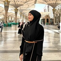 Gaya Erina selama umrah juga selalu terlihat simpel namun tetap elegan dan menawan. Seperti gayanya memadukan busana serba hitam dengan ikat pinggang berwarna coklat. Foto: Instagram/@kaesangp/@erinagudono