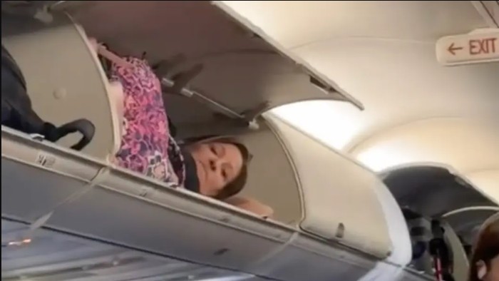 Penumpang tidur di kabin tas pesawat.
