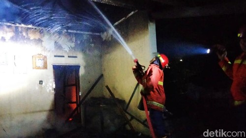 Petugas memadamkan api dalam kebakaran rumah di Karangasem.