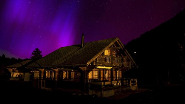 Cahaya Utara, atau Aurora Borealis, menerangi langit malam di atas pegunungan di Le Col des Moss, Armont-Dessés Pass, Swiss, Sabtu dini hari, 11 Mei 2024.  (Jean-Christophe Baut/AP melalui Keystone)