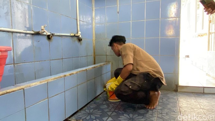 Cecep saat bersihkan toilet masjid.
