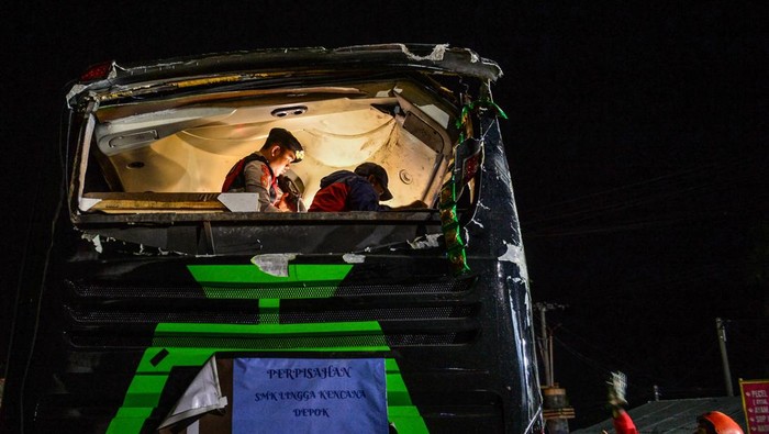 Petugas kepolisian mengevakuasi korban kecelakaan bus pariwisata di Desa Palasari, Kecamatan Ciater, Kabupaten Subang, Jawa Barat, Sabtu (11/5/2024). Dinas Kesehatan Kabupaten Subang mencatat, dalam kecelakaan bus yang membawa rombongan siswa SMK Lingga Kencana Depok tersebut untuk sementara terdapat 11 orang korban meninggal dunia yang terdiri dari 10 orang siswa SMK dan 1 orang pemotor asal Cibogo Kabupaten Subang. ANTARA FOTO/Raisan Al Farisi/aww.