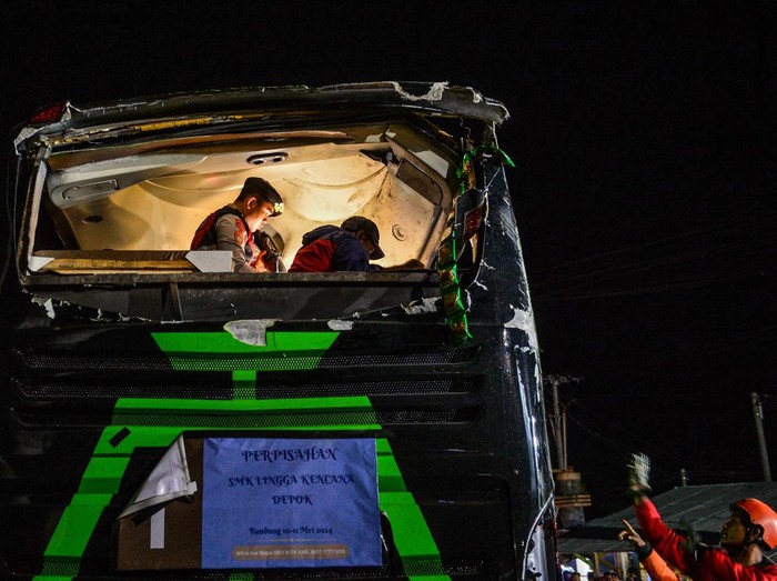 Petugas kepolisian mengevakuasi korban kecelakaan bus pariwisata di Desa Palasari, Kecamatan Ciater, Kabupaten Subang, Jawa Barat, Sabtu (11/5/2024). Dinas Kesehatan Kabupaten Subang mencatat, dalam kecelakaan bus yang membawa rombongan siswa SMK Lingga Kencana Depok tersebut untuk sementara terdapat 11 orang korban meninggal dunia yang terdiri dari 10 orang siswa SMK dan 1 orang pemotor asal Cibogo Kabupaten Subang. ANTARA FOTO/Raisan Al Farisi/aww.