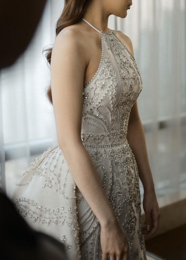 Desainer couture ini menciptakan gaun halterneck yang dihiasi keanggunan dengan rangkaian manik-manik serta kristal yang diharmonisasikan aksen drapery. Foto: Instagram/@axioo @thebridestory @hiantjen @dhirmanputra