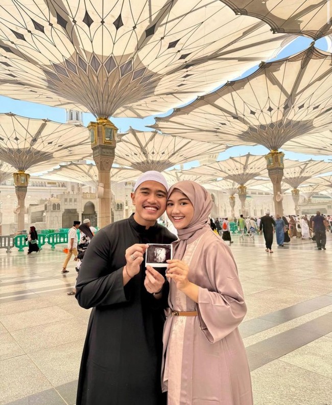 Melalui akun Instagram pribadi masing-masing, Erina Gudono dan Kaesang Pangarep mengumumkan kabar sedang menantikan kehadiran anak pertama pada Mei lalu. Mereka mengunggah foto saat sedang beribadah umrah. Memegang foto USG, menantu Presiden Jokok Widodo ini mengenakan gamis berwarna lavender yang dipadukan dengan slim-belt. (Foto: Instagram kaesangp/erinagudono)