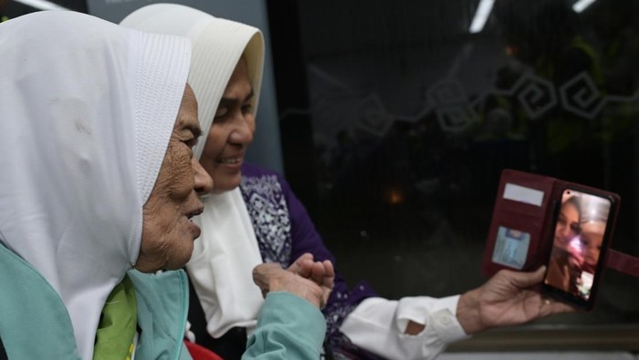 Jamaah calon haji melakukan panggilan video sebelum pemberangkatan ke Tanah Suci di Bandara Soekarno Hatta, Tangerang, Banten, Sabtu (11/5/2023). Sebanyak 393 jamaah calon haji Indonesia kloter pertama embarkasi Jakarta-Pondok Gede (JKG 01) resmi diberangkatkan ke Tanah Suci. ANTARA FOTO/Sigid Kurniawan.