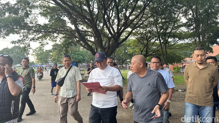 Pj Gubernur Sulsel Bahtiar Baharuddin saat dijelaskan sebuah dokumen Stadion di GOR Sudiang oleh Kadispora Sulsel Suherman.