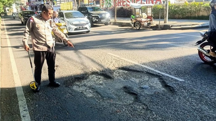 Polisi melakukan olah TKP di lokasi kecelakaan di Jalan Hertasning Makassar.