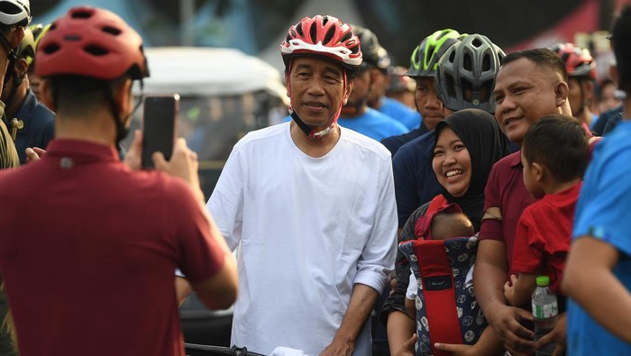 Presiden Joko Widodo (tengah) menerima ajakan swafoto saat berolahraga di hari bebas kendaraan bermotor atau Car Free Day, kawasan Bundaran HI, Jakarta, Minggu (12/5/2024). Selain bersepeda, Presiden juga menyapa serta menerima ajakan berswafoto masyarakat. ANTARA FOTO/Akbar Nugroho Gumay/Spt.