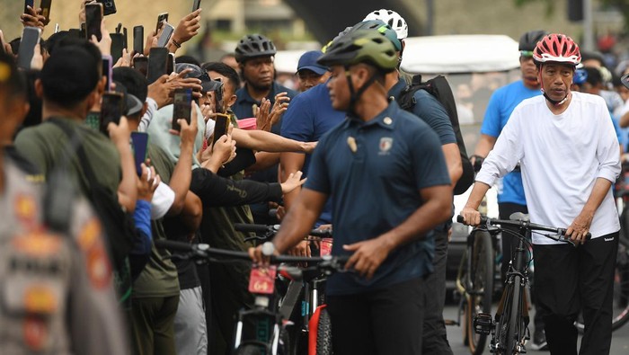 Presiden Joko Widodo (tengah) menerima ajakan swafoto saat berolahraga di hari bebas kendaraan bermotor atau Car Free Day, kawasan Bundaran HI, Jakarta, Minggu (12/5/2024). Selain bersepeda, Presiden juga menyapa serta menerima ajakan berswafoto masyarakat. ANTARA FOTO/Akbar Nugroho Gumay/Spt.