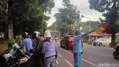 Salah satu petugas parkir di Lapangan Monumen Perjuangan Rakyat Bali Bajra Sandhi, Made Kanta, saat memberikan pelayanan kepada warga, Sabtu (11/5/2024). (Ni Made Lastri Karsiani Putri/detikBali)