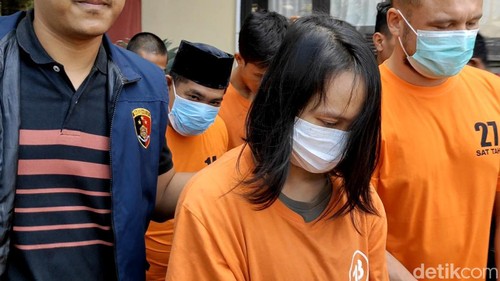 Septyani Surya digiring ke ruang tahanan Polres Badung, Sabtu (11/5/2024). Ia ditangkap lantaran menipu emak-emak dengan modus menjual minyak goreng murah. (Foto: Agus Eka/detikBali)