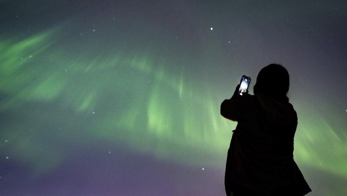 The Northern Lights, or Aurora Borealis, illuminate the night sky over the mountains in Le Col des Mosses pass, Ormont-Dessous, Switzerland, during the early hours of Saturday, May 11, 2024. (Jean-Christophe Bott/Keystone via AP)