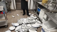 Karena terlalu sibuk, salah satu pegawai resto ini tak sengaja memecahkan ratusan piring di area dapur. Foto: Pool/Site