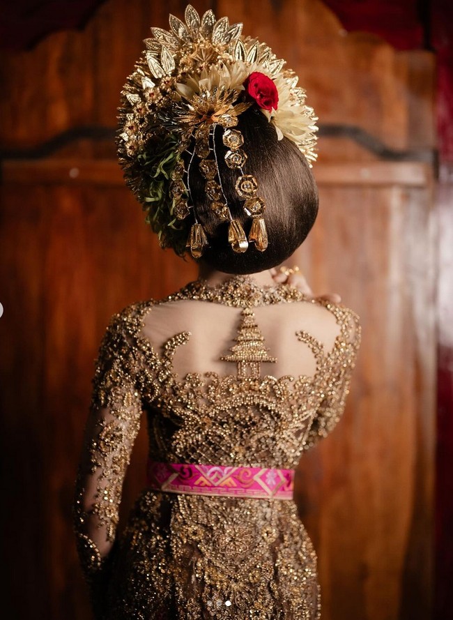 Salah satu detail yang menjadi sorotan adalah bordiran di bagian punggung. Bordiran tersebut menggambarkan identitas Mahalini sebagai gadis Bali, berbentuk sebuah pura. Foto: Instagram/@axioo @thebridestory @hiantjen