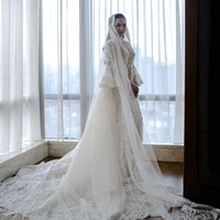 Bridal robe kedua datang dari karya desainer Monica Ivena. Outer bergaya vintage klasik ini sarat akan detail dengan penerapan bordir, payet, manik-manik serta mutiara. Bridal robe semakin terlihat indah berkat lengan ruffle bervolume dan veil sepanjang 4 meter. Foto: Instagram/@axioo @thebridestory @hiantjen