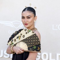 Tak berhenti di situ, nasionalismenya juga hadir lewat jajaran aksesori. Berpadu dengan perhiasan emas yang chunky, headpiece bergaya tusuk konde kembang goyang mempermanis penampilan perempuan 37 tahun itu. (Foto: Tommaso Boddi/GETTY IMAGES NORTH AMERICA/Getty Images via AFP)