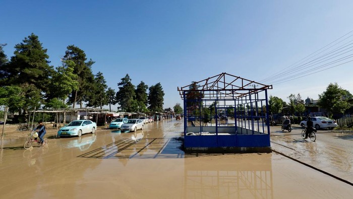 Traffic moves as municipality workers clear debris from the streets after flooding in Sheikh Jalal district, Baghlan province, Afghanistan May 12, 2024. REUTERS/Sayed Hassib