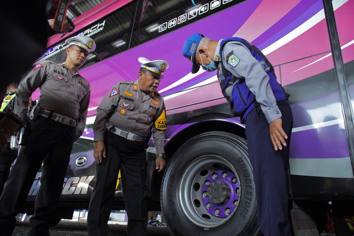 Polisi bersama petugas Dinas Perhubungan melakukan pemeriksaan kelaikan angkutan bus pariwisata di salah satu garasi biro perjalanan pariwisata di Lumajang, Jawa Timur, Senin (13/5/2024). Pemeriksaan kelaikan angkutan umum meliputi kelengkapan surat-surat dan komponen kendaraan serta pengecekan kesehatan sopir bus tersebut untuk mencegah risiko kecelakaan transportasi darat menjelang liburan sekolah. ANTARA FOTO/Irfan Sumanjaya/tom.