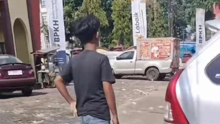 Jukir liar palak pengendara mobil Rp 30 ribu di Asrama Haji Sudiang Makassar.