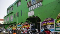 Karangan bunga berjejer di depan dan parkiran sekolah. 