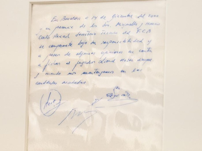 A Bonhams staff member holds up a napkin on which a written commitment was made to then 13-year-old soccer player Lionel Messi from Argentina for a contract from FC Barcelona in December 2000 is on display at Bonhams in London, England, Wednesday, May 8, 2024 before it is offered at auction. ( Jordan Pettitt/PA via AP)