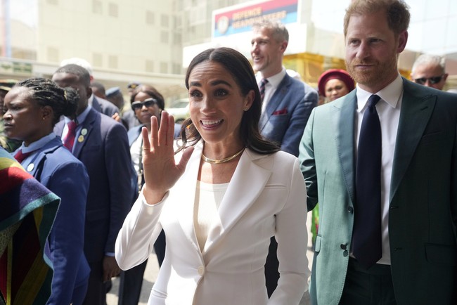 Meghan Markle berganti busana saat mengunjungi Kantor Pertahanan Nigeria di Abuja. Dia mengenakan setelan blazer berwarna putih dari brand Altuzarra dan sepatu high heels Manolo Blahnik. Foto: AP Photo/Sunday Alamba